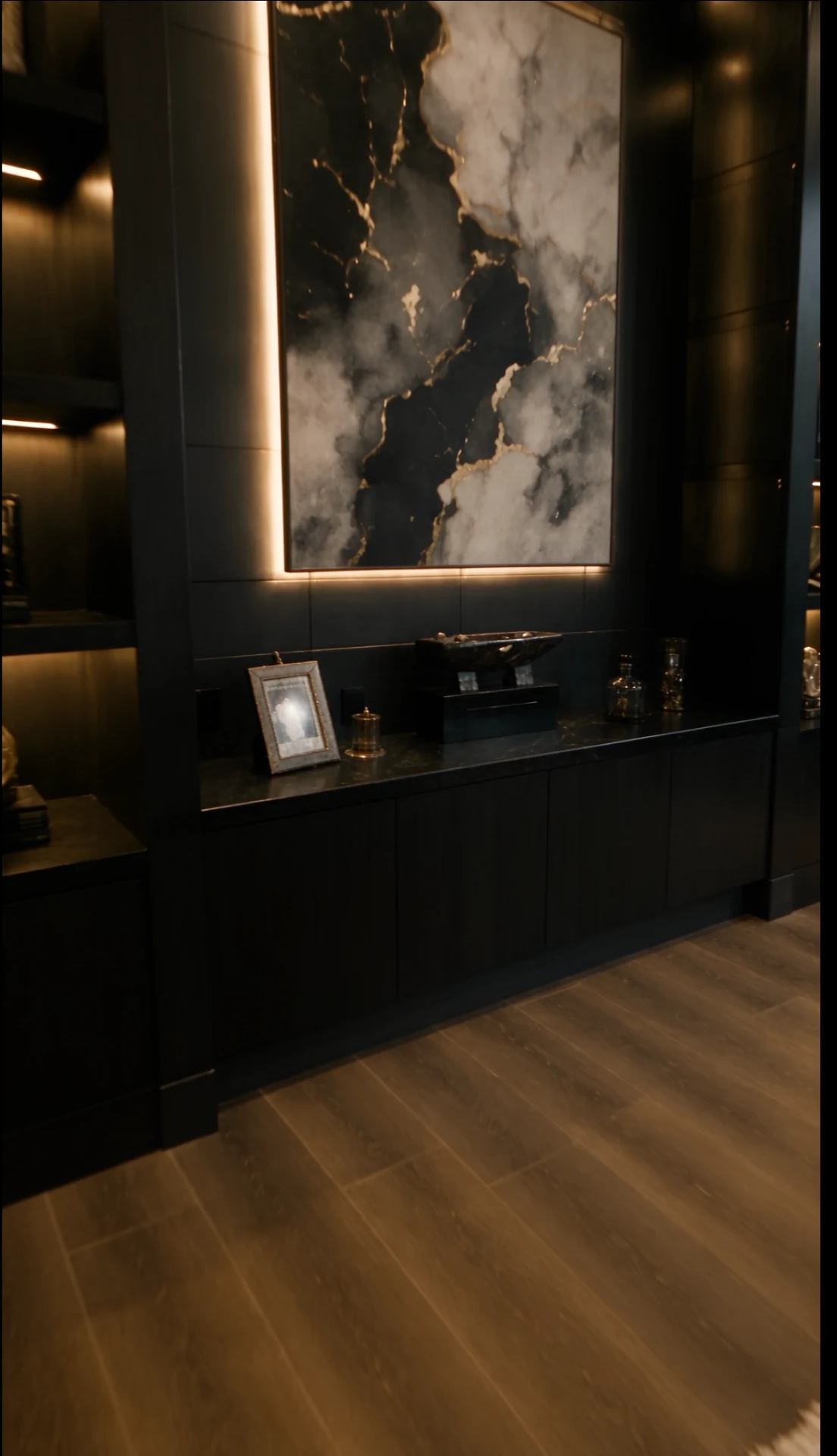 Backlit marble art panel above a black credenza in the basement office