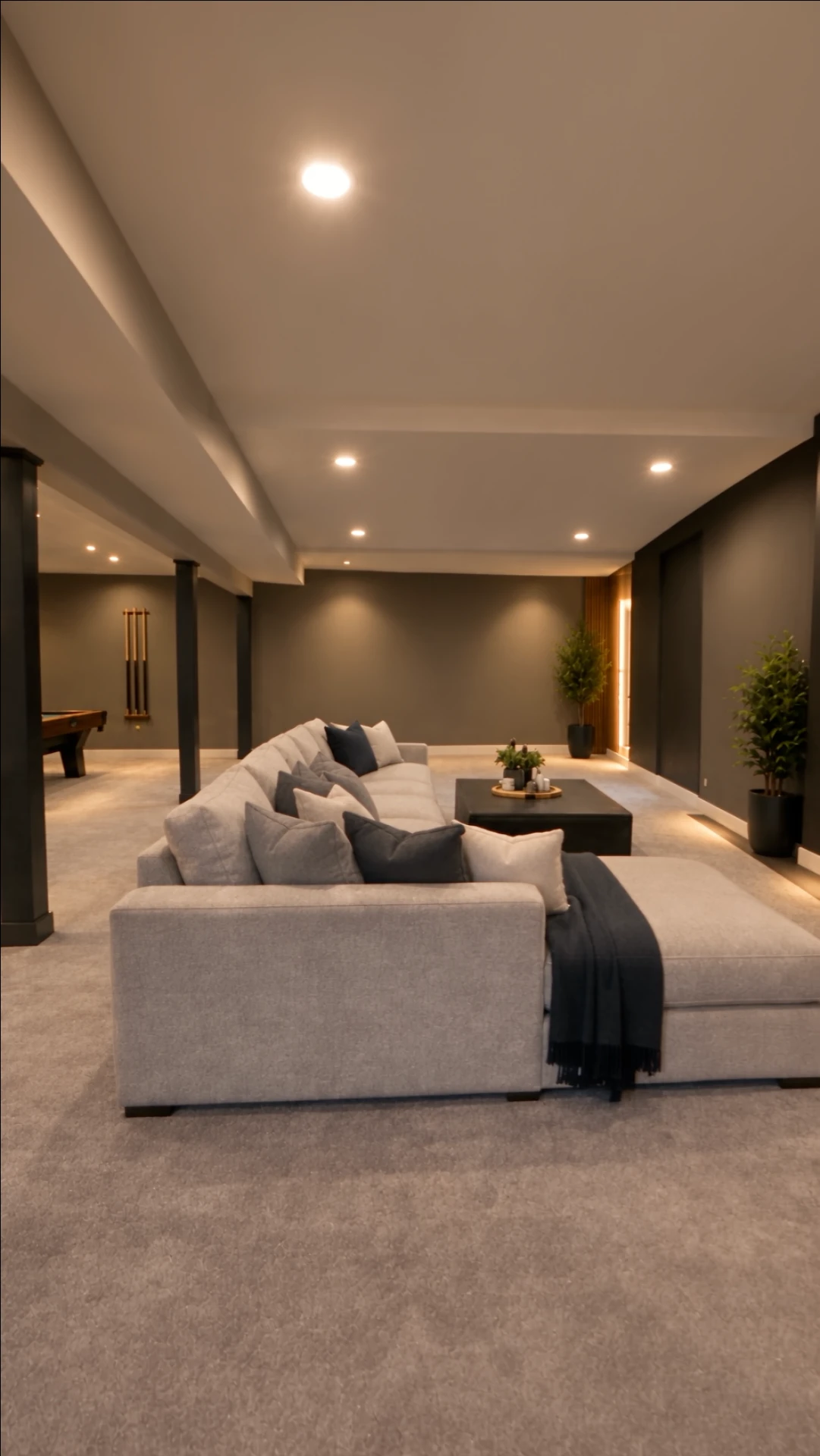 Light gray sectional sofa with accent pillows in the basement lounge